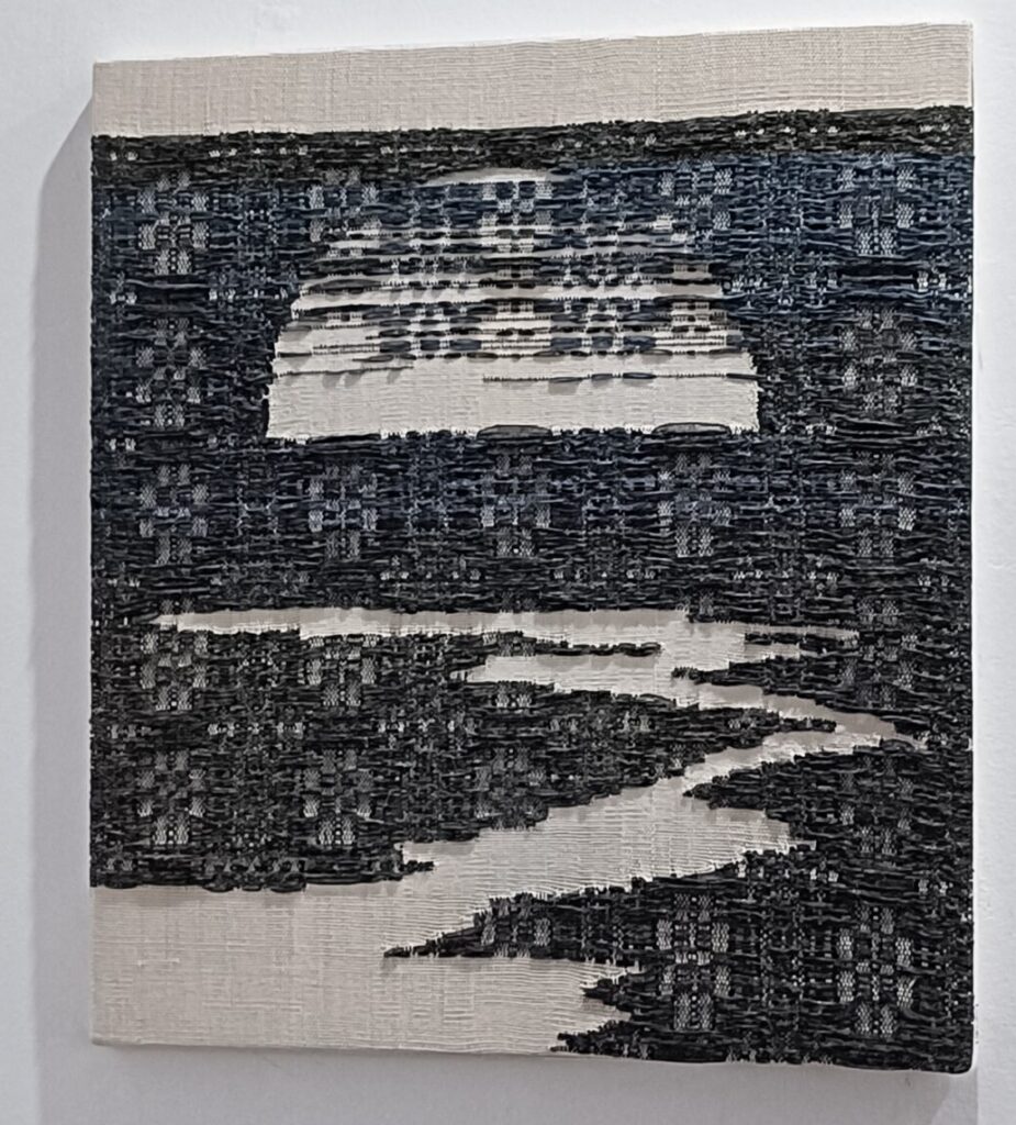 Tkanina naciągnięta na ramę, wątek ciemny niebieski i czarna bawełna, osnową beżowa bawełna. Radziuszka, tkanina przetykana. Wykonanie Beata Palikot Borowska