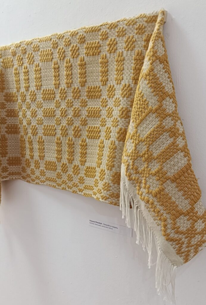 Tkanina wykonana techniką radziuszki. Osnowa bawełna biała, wątek wełna zółta. Wykonała Urszula Mendryk