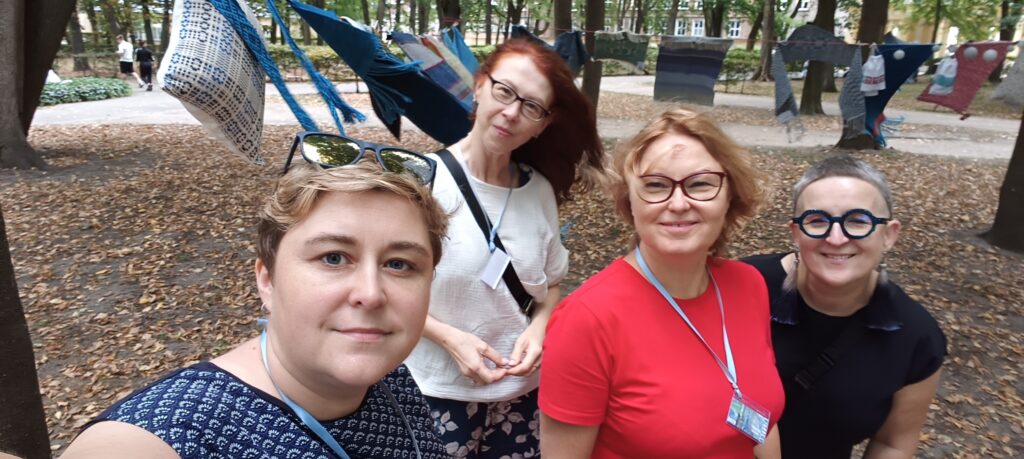Aleksandra Staszak, Urszula Mendryk, Katarzyna Daniewicz, Beata Palikot-Borowska a w tle w Parku Branickich w Białymstoku na sznurkach zawieszone tkaniny w odcieniach niebieskiego w ramach Festiwalu kobiet Venus sea blue.