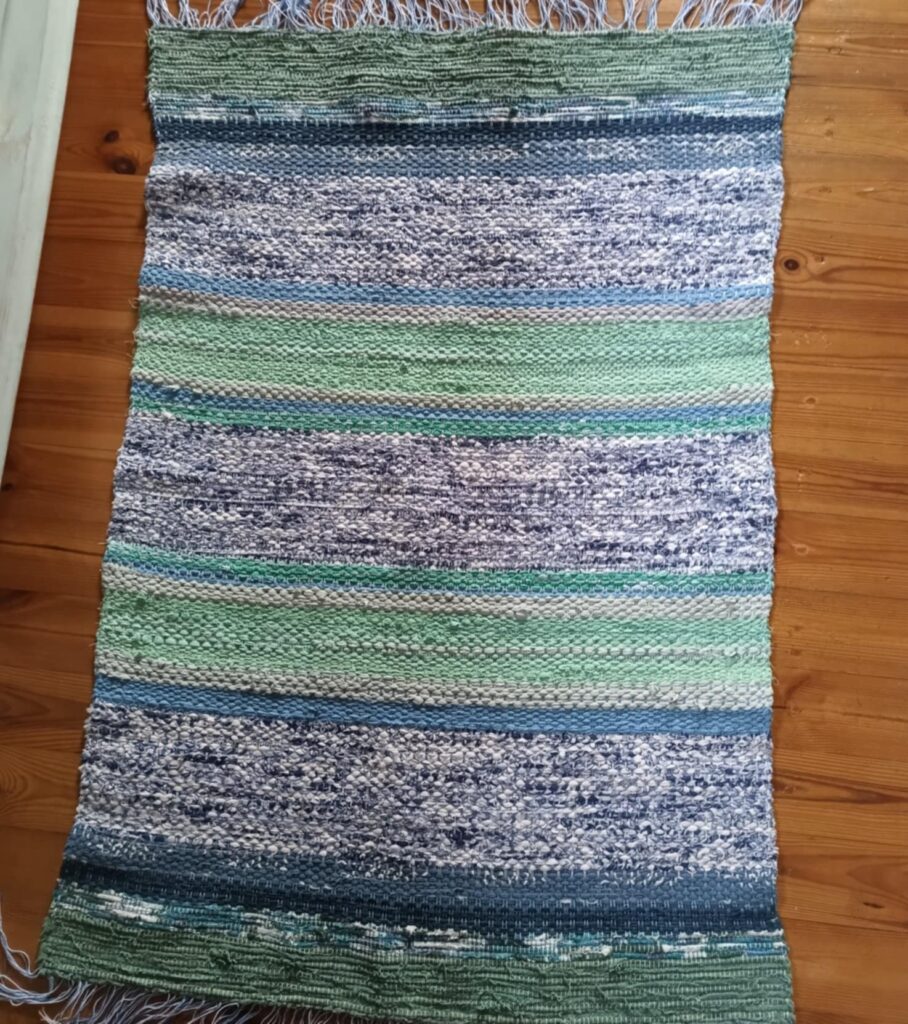 Pistacje w niebie chodnik tzw. szmaciak autorstwa Urszuli Mendryk. Kolory wątku zielony, niebieski, biały.